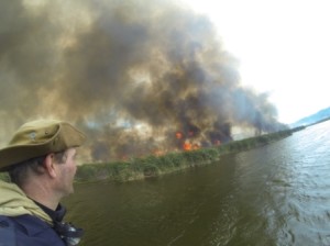 The Otter Bush Camp burning as seen from the Rondevlei water. 