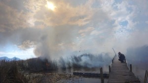 A lookout checks for spot fires behind his crew mates. 